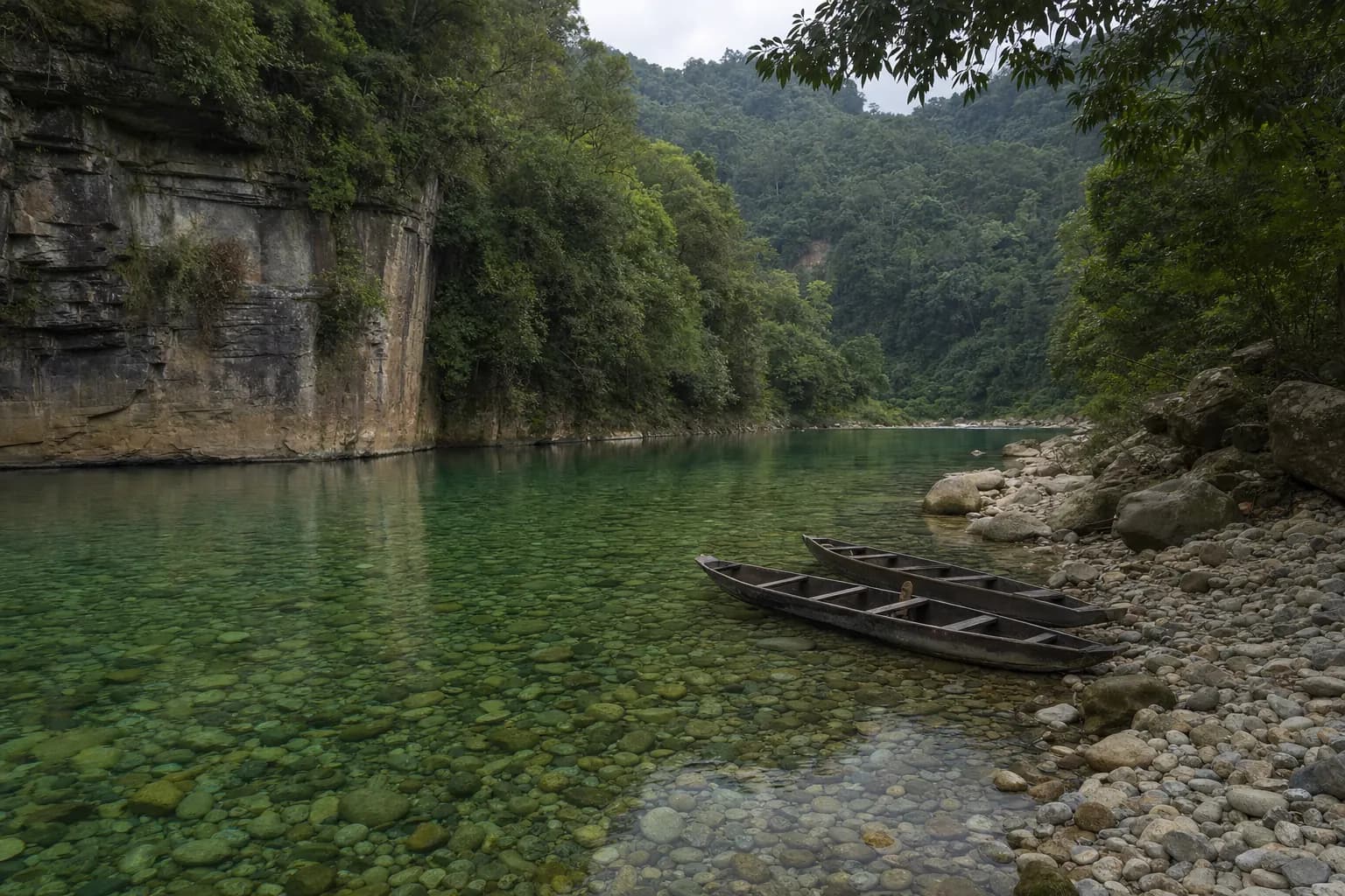 Wooden boats on the transparent green water of the Dawki river
