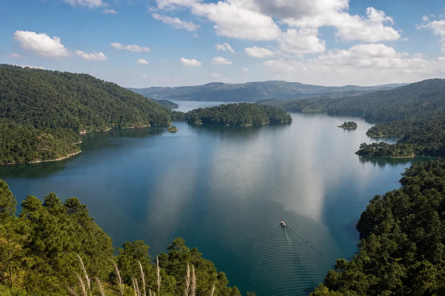 The blue-green water of Umiam lake among pine-covered hills