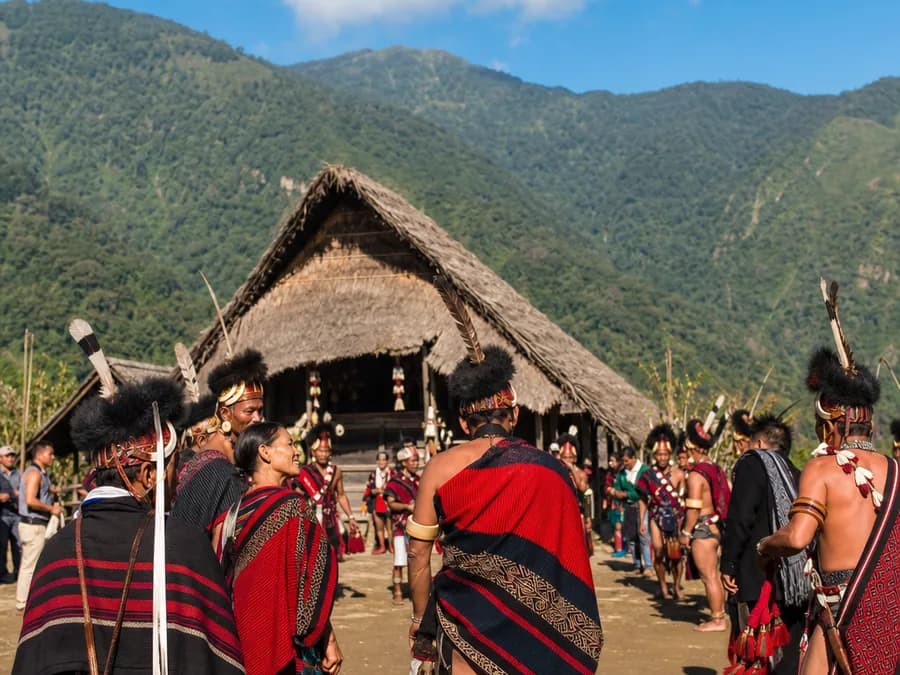 Naga performers in traditional shawls and headdresses at an outdoor cultural festival