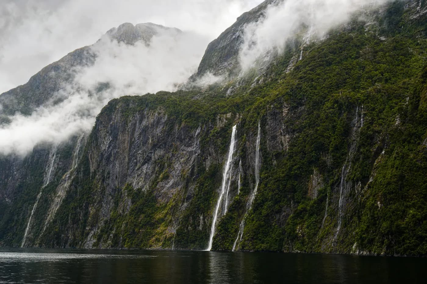 A fiord with sheer green cliffs and waterfalls