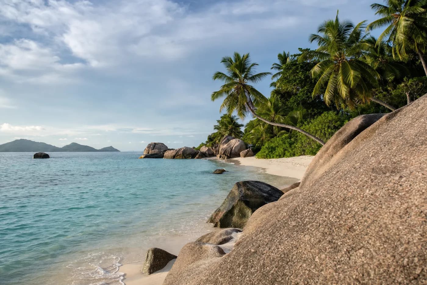 Granite boulders on a white beach with turquoise water