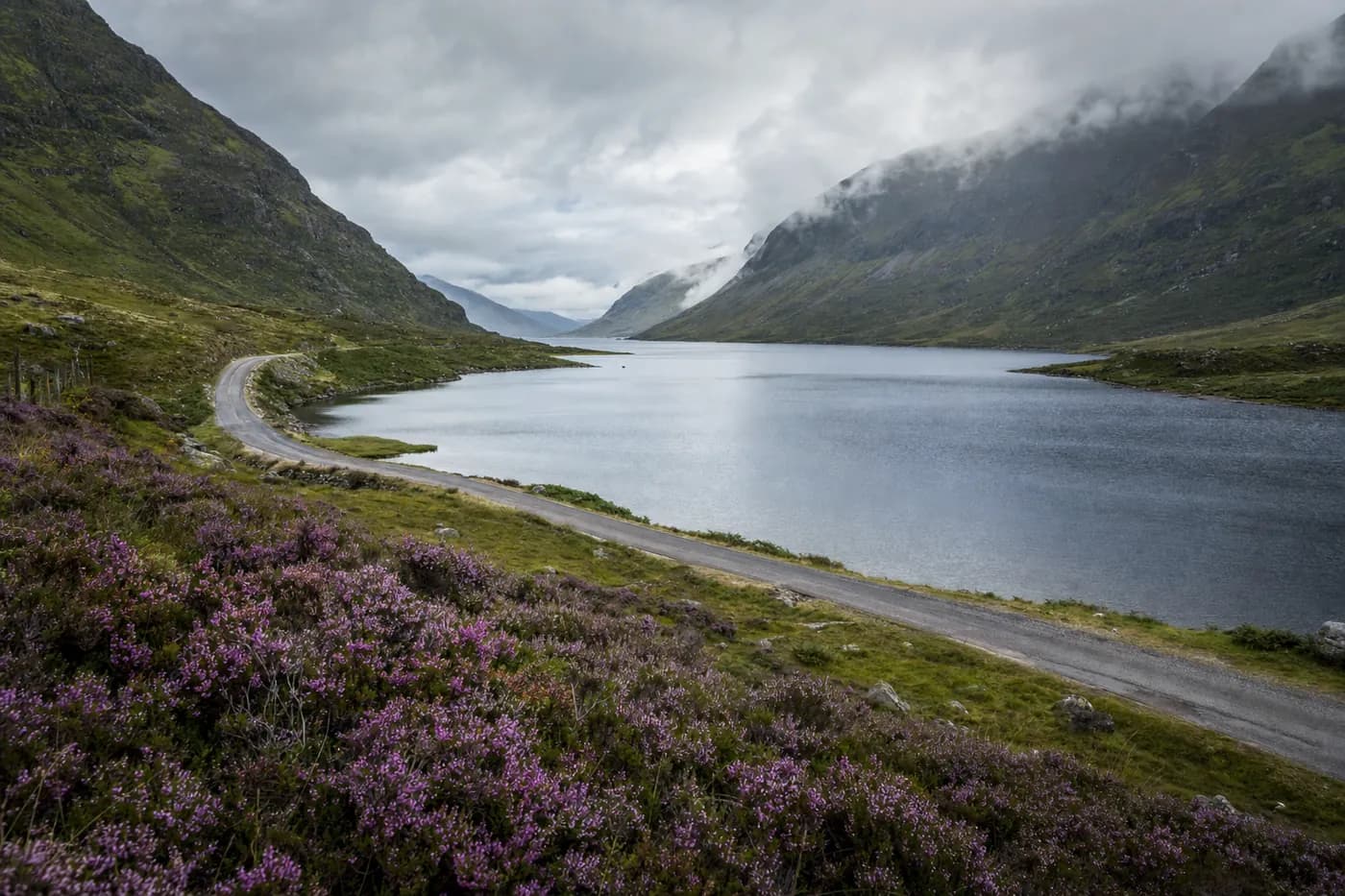A long still loch between green hills in the Scottish Highlands