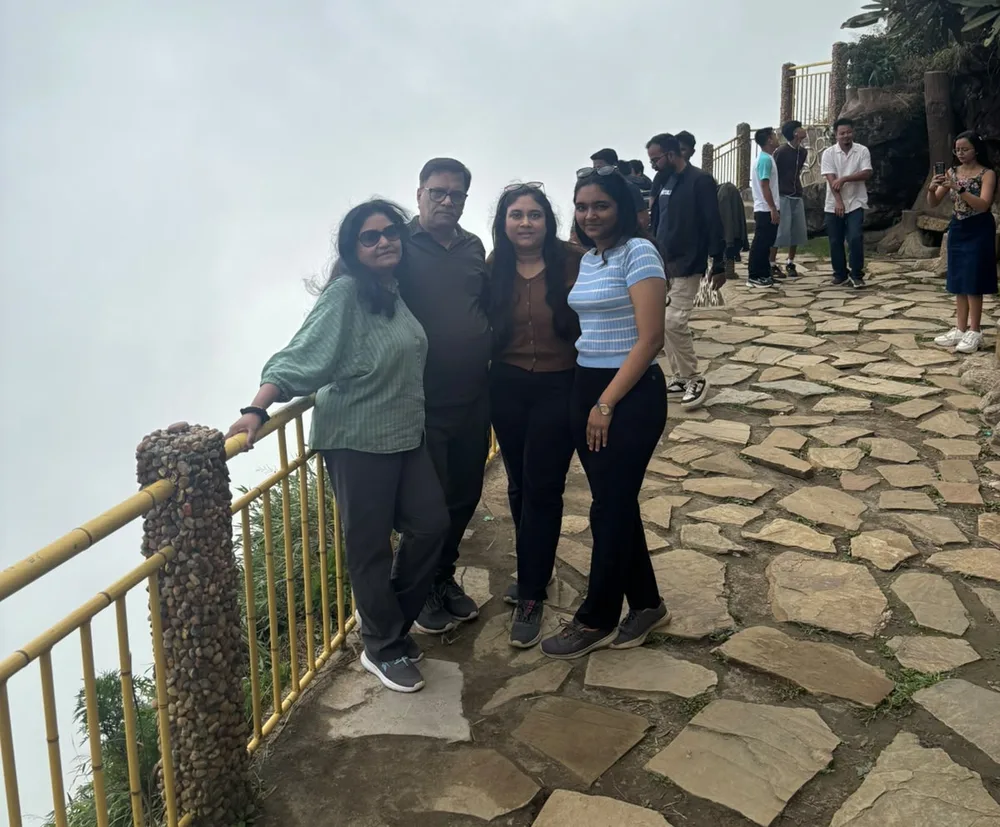 Ayushi and her family at a misty viewpoint in Meghalaya on their trip with Smarto